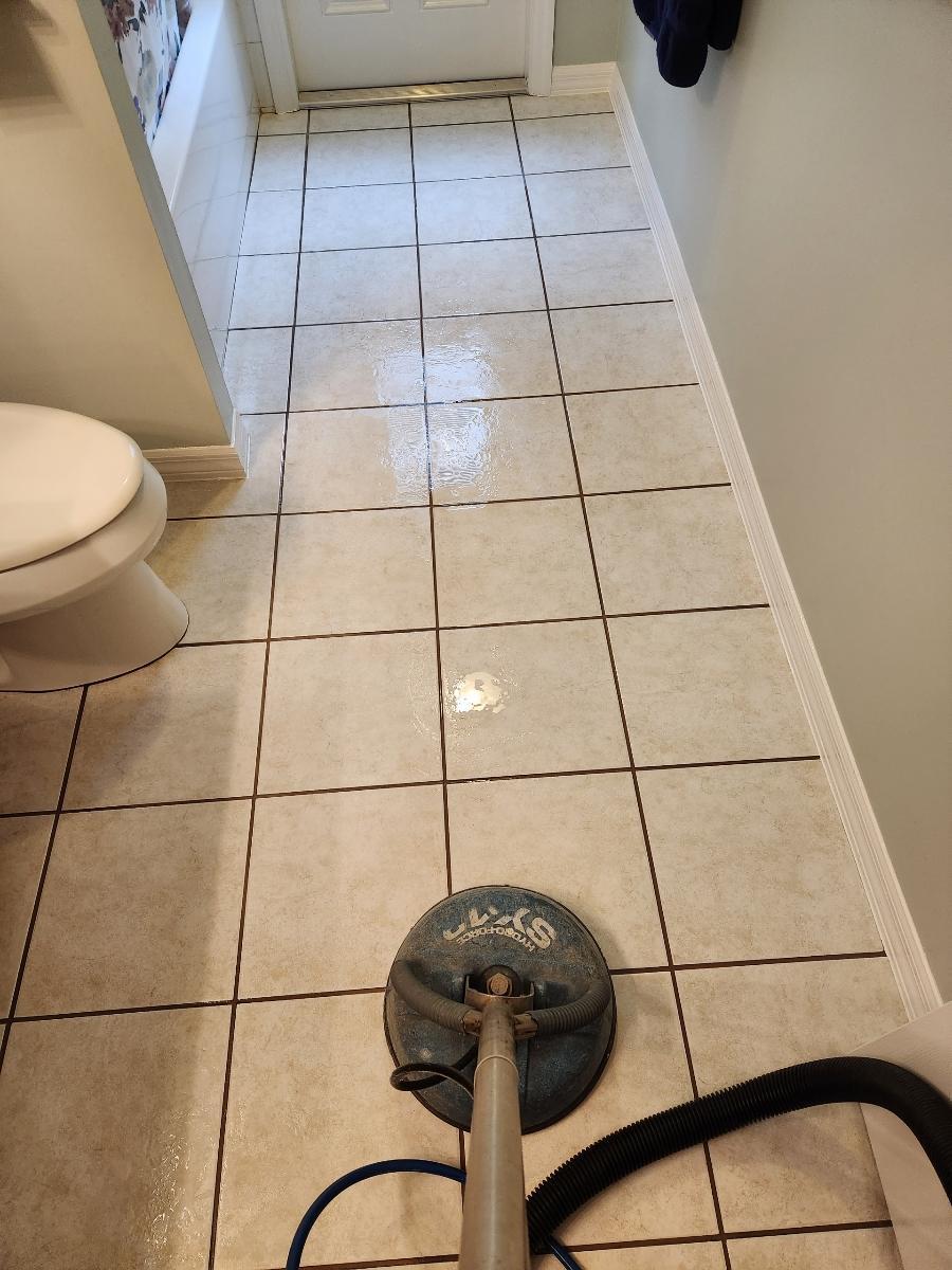 close-up of dirty grout lines between the tiles being cleaned in a bathroom