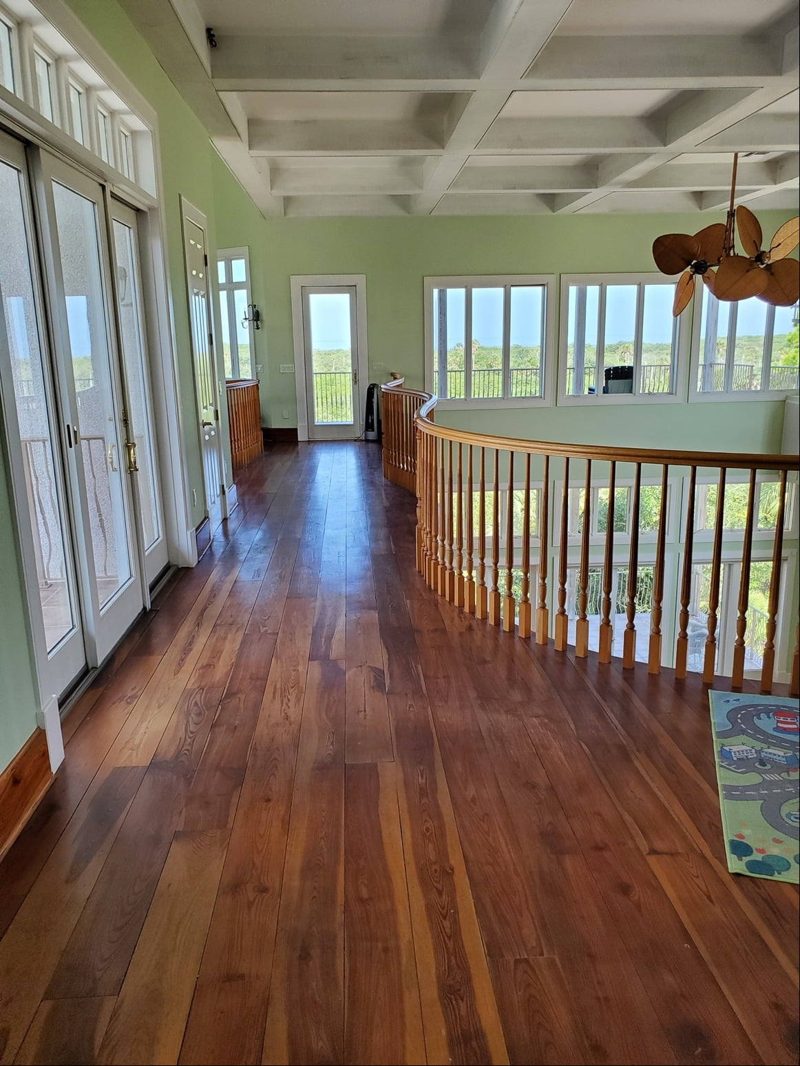 A house with laminate floors, glass doors and staircase railing