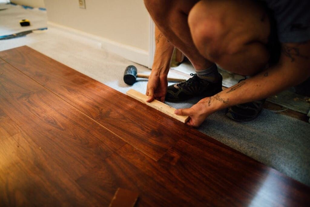 Cropped photo of a person installing vinyl floor
