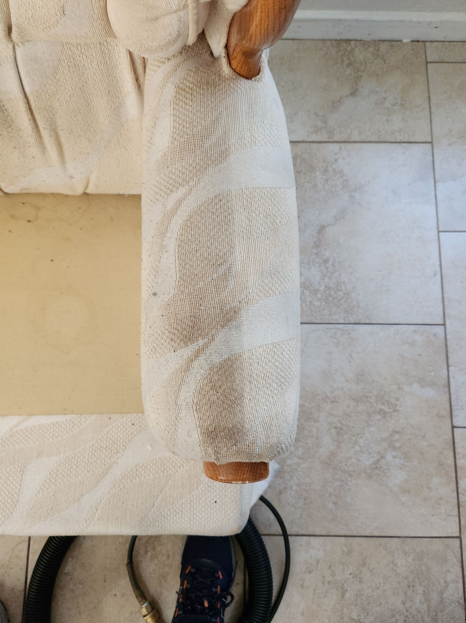 An armrest of a sofa before cleaning