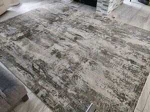 A gray wool rug being carefully cleaned, avoiding common cleaning mistakes