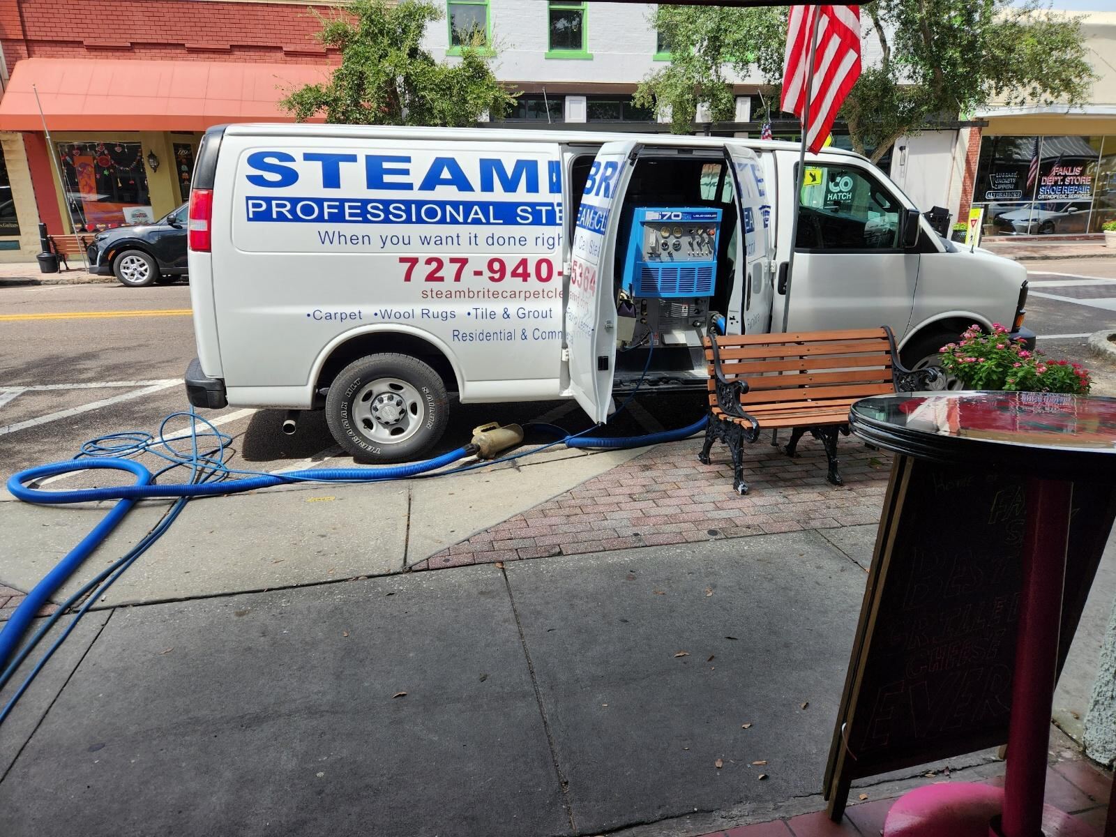 An image of a Steambrite Cleaning Service van outisfde a cafe