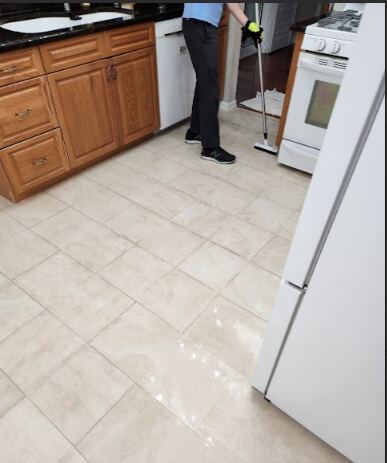a person cleaning kitchen tiles.