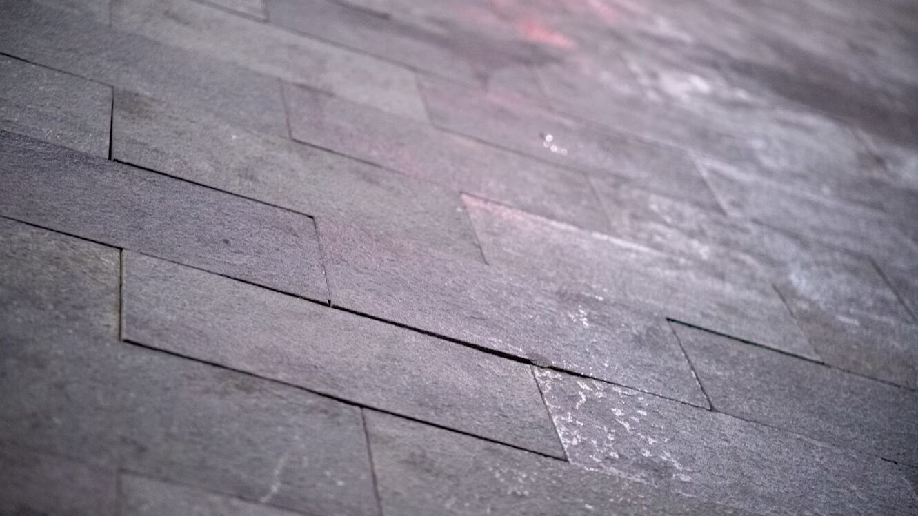 Dark grey tiled flooring, showing visible salt residue and light discoloration