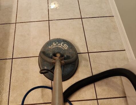 Close-up of white tiled flooring with visible discolored grout lines