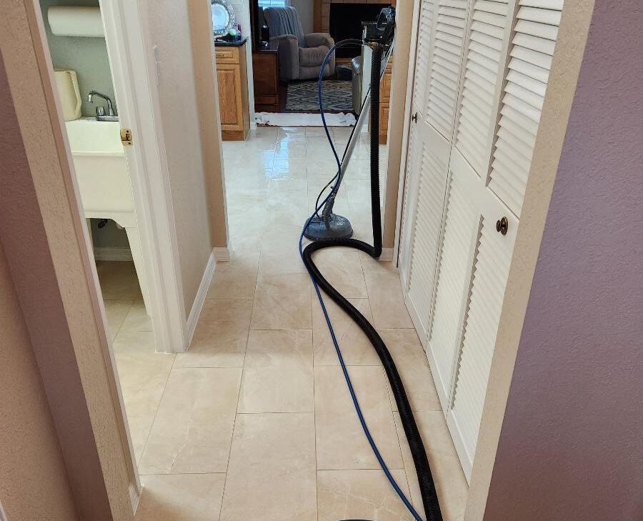 A big tile and grout cleaning machine in a home with other upholstery in background.