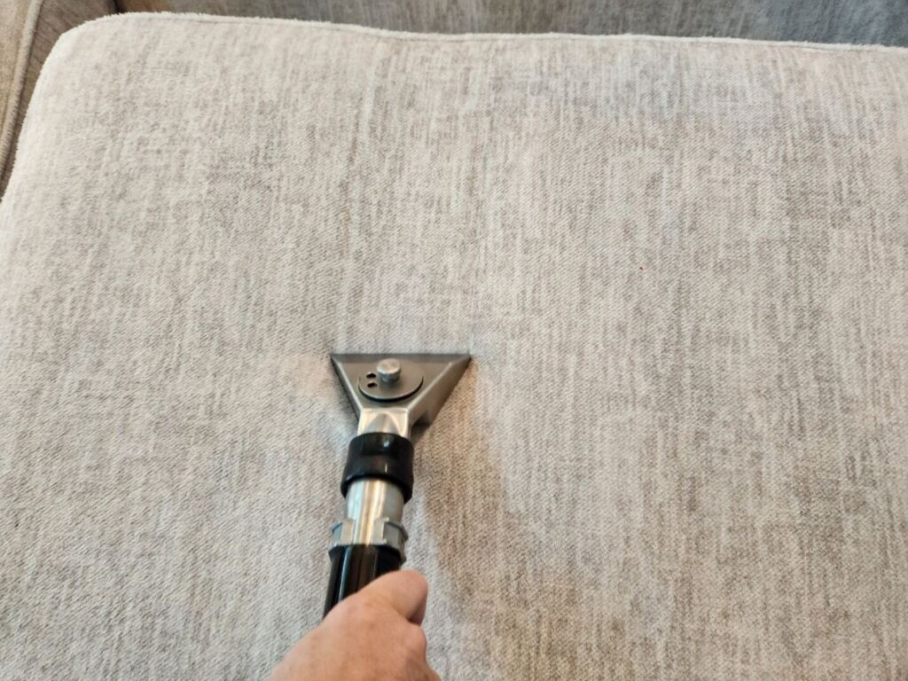 a cleaning service removing dirt from a cushion