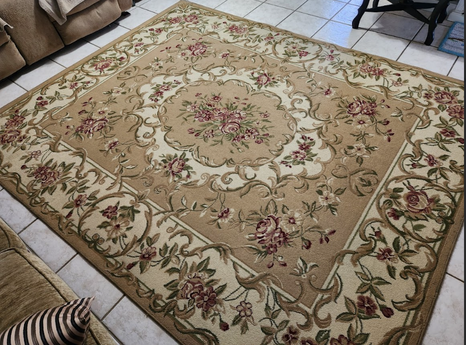 Clean floral area rug laid out on tiled flooring