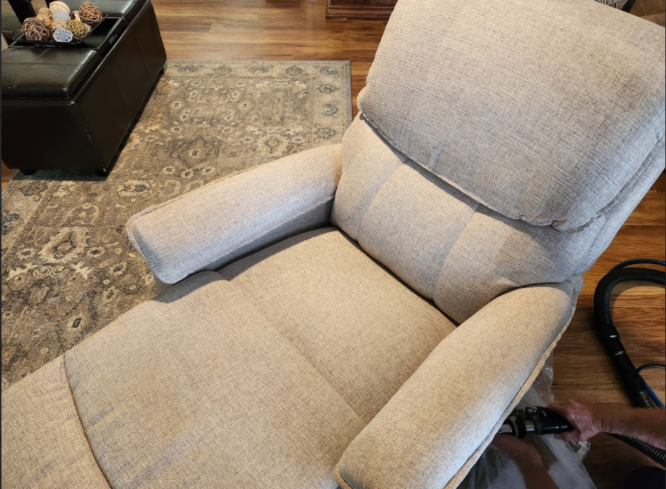 Professional cleaning of a fabric recliner inside a living room