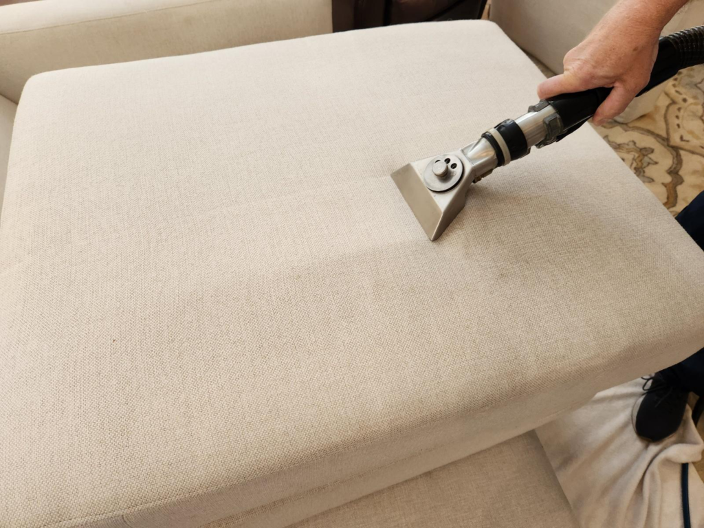 close-up of a sofa cushion being vacuumed