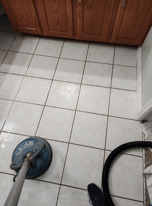 Floor cleaning machine on tile next to carpeted area