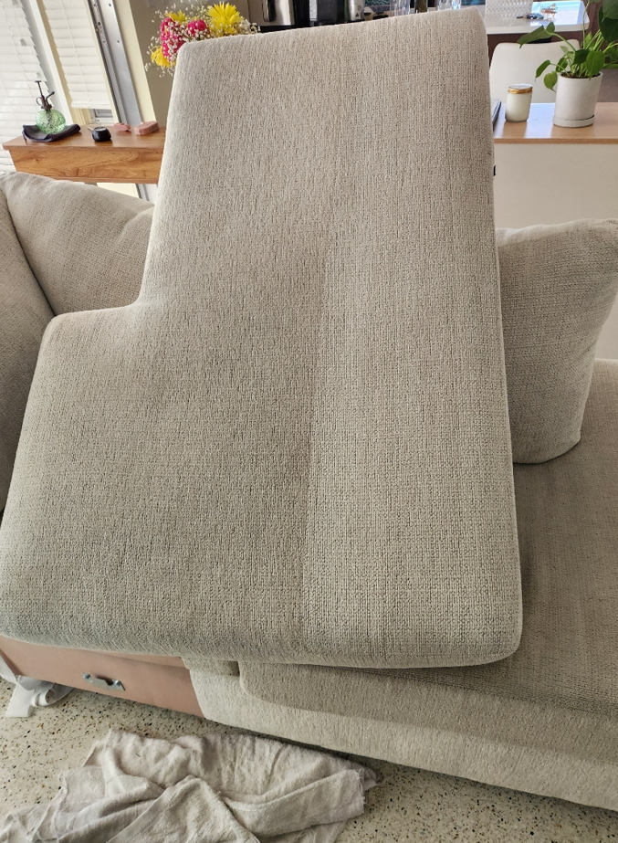 Clean upholstered armchair with smooth, refreshed fabric after professional deep cleaning