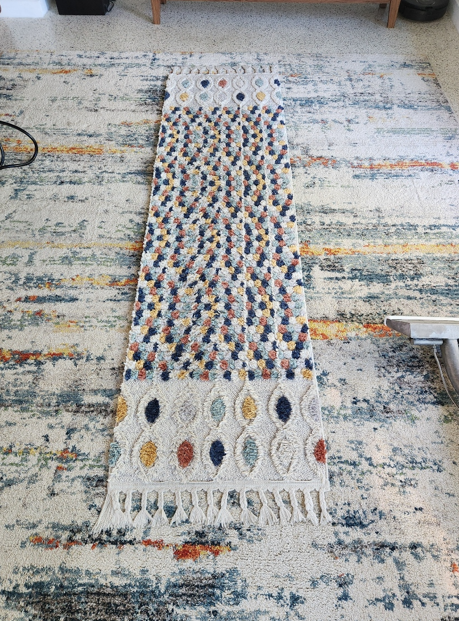 Decorative runner placed over large area rug during staged cleaning process