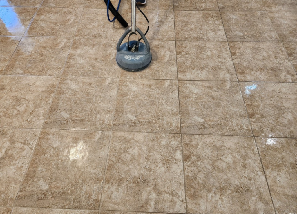 Tile floor being cleaned with professional equipment to remove buildup and residue