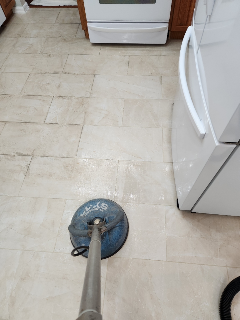 grime stuck between kitchen tiles being cleaned with the help of a rotary scrubber