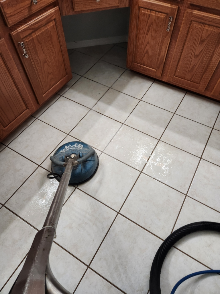 kitchen floor being cleaned using a rotary scrubber for cleaner grout lines between tiles