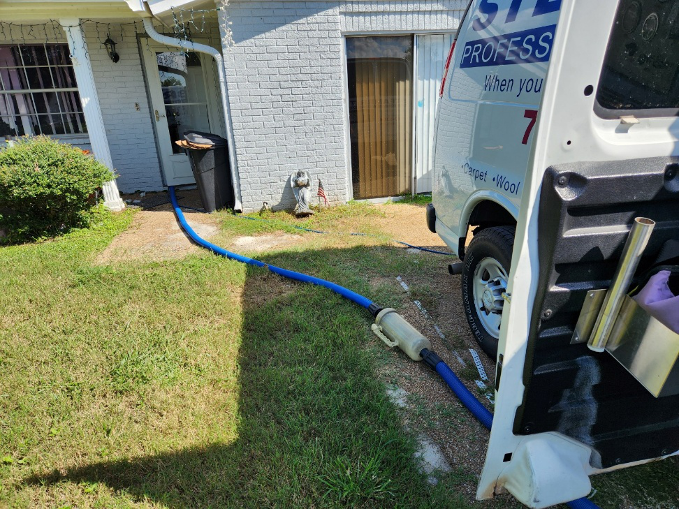 This photo shows a van outside a house equipped with cleaning supplies.