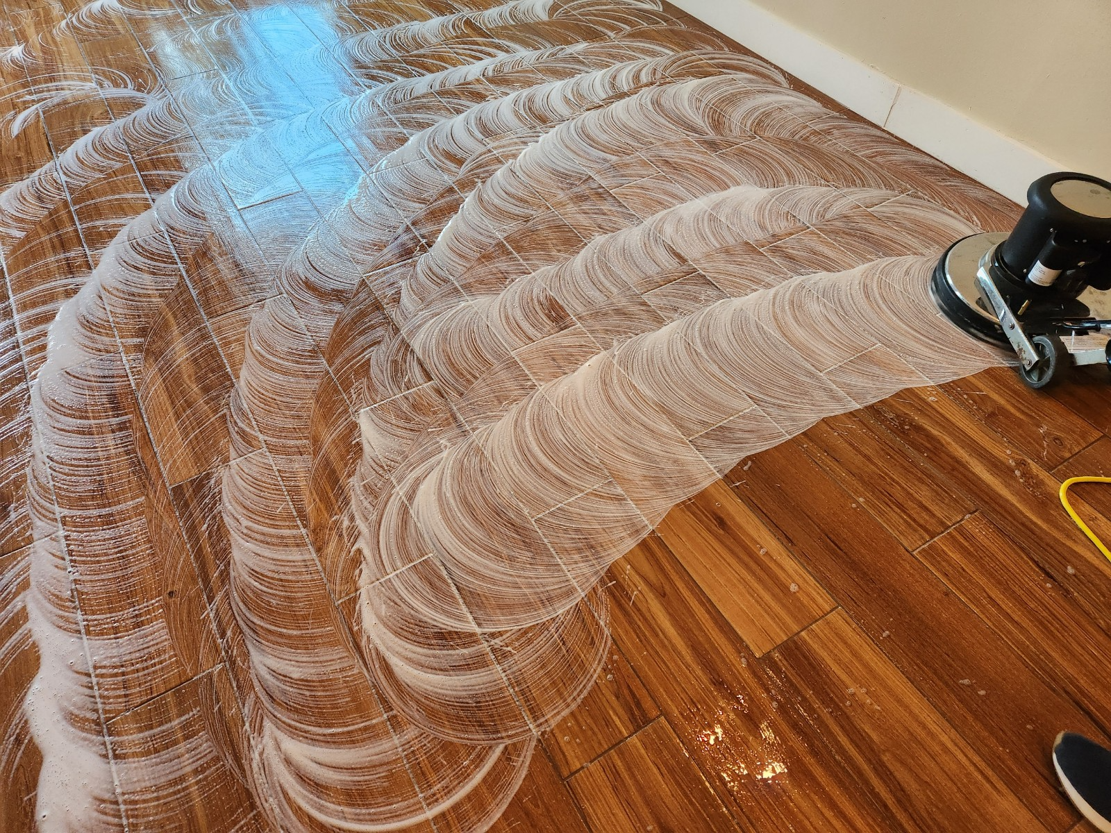 a rotary scrubber being used to clean wooden flooring