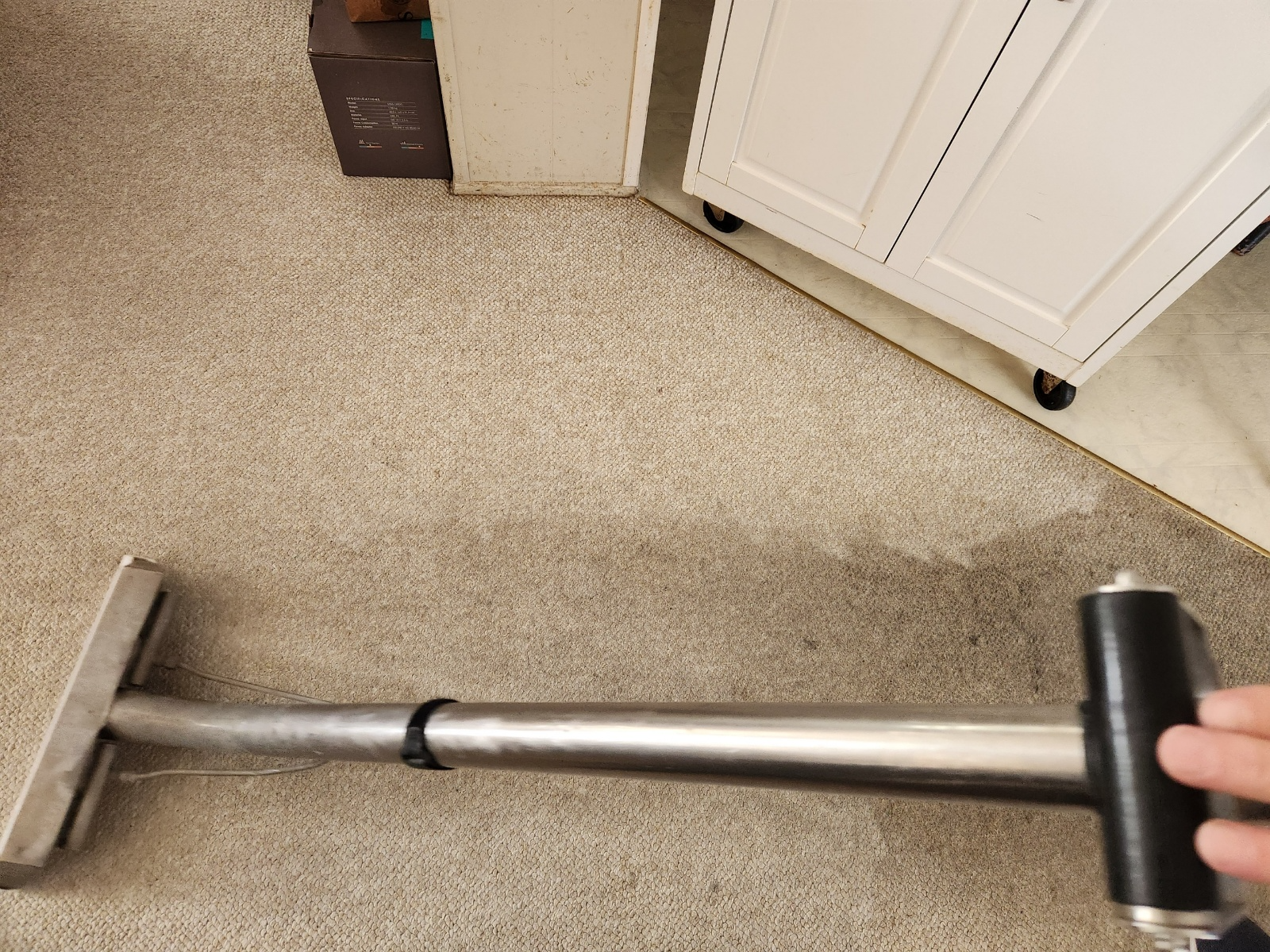 a silver and black vacuum cleaner being used to clean a carpet