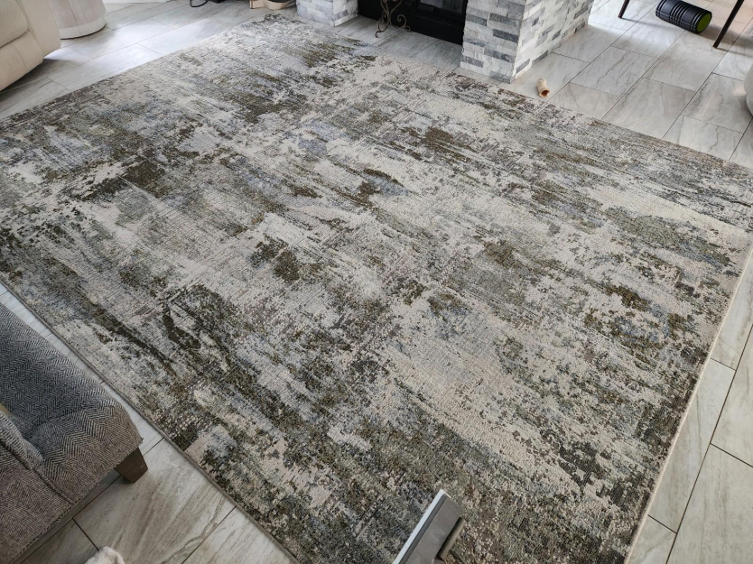 This photo shows a wool rug in the middle of a living room.