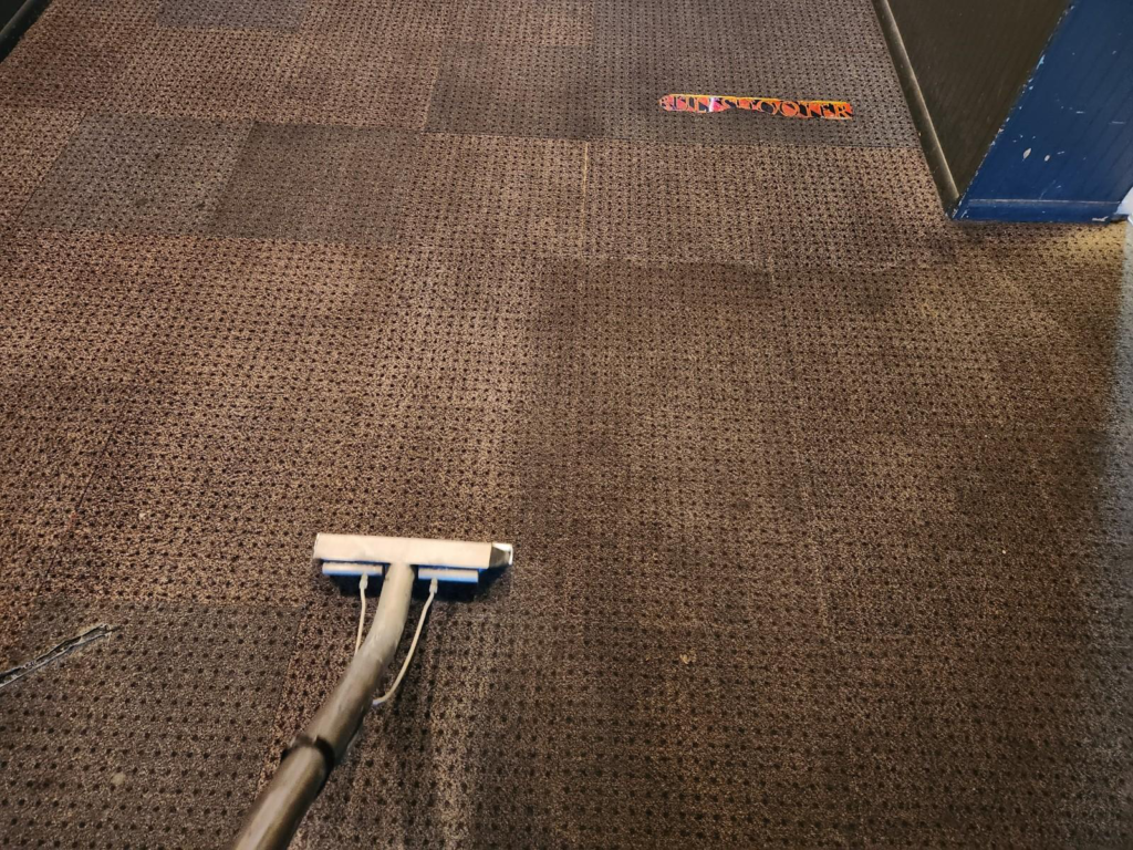 An image of a dirty commercial carpet being cleaned