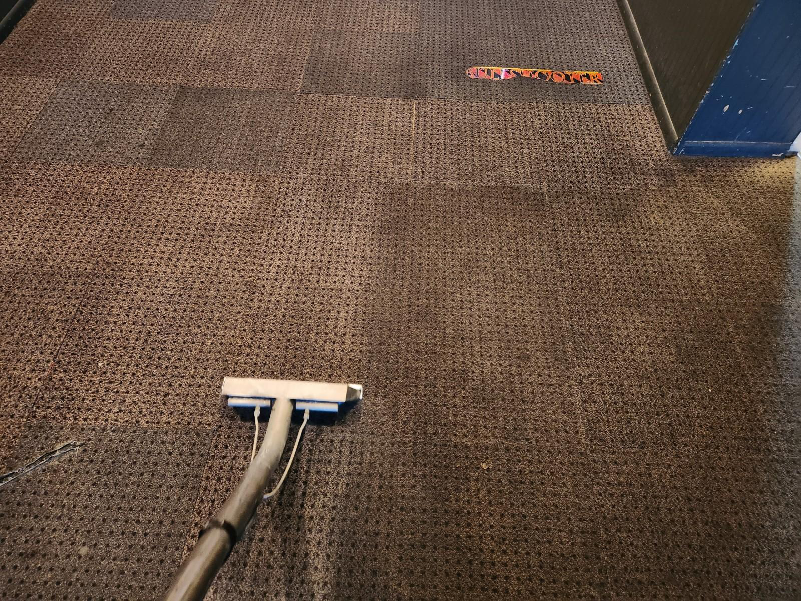 An image of a dirty commercial carpet being cleaned