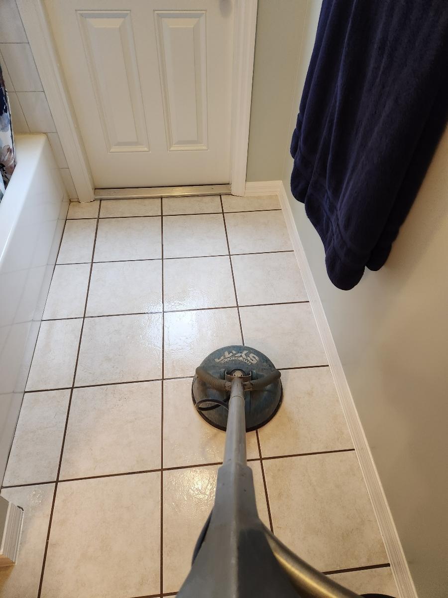 a scrubber being used to clean tiles