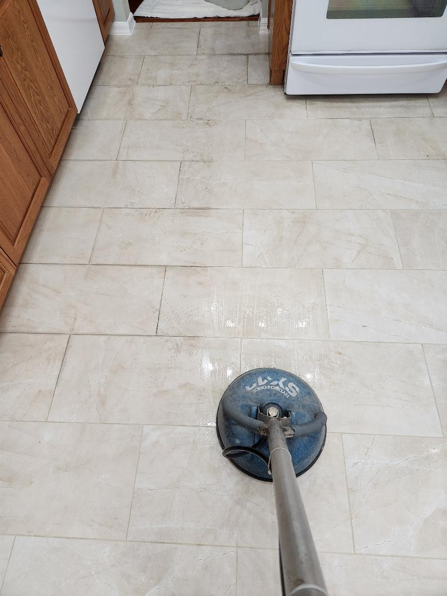 An image of white tiles being steam cleaned